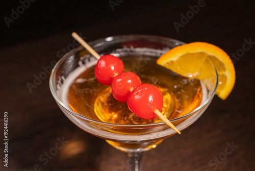 A champagne cocktail in a beautiful glass with pickled berries on a skewer
