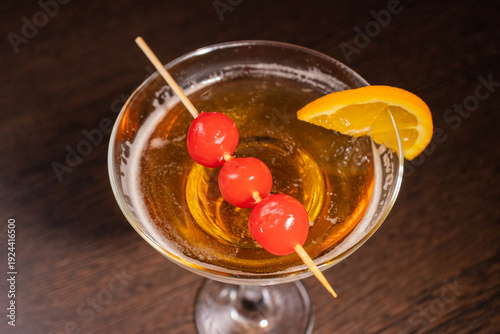 A champagne cocktail in a beautiful glass with pickled berries on a skewer