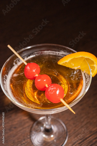 A champagne cocktail in a beautiful glass with pickled berries on a skewer
