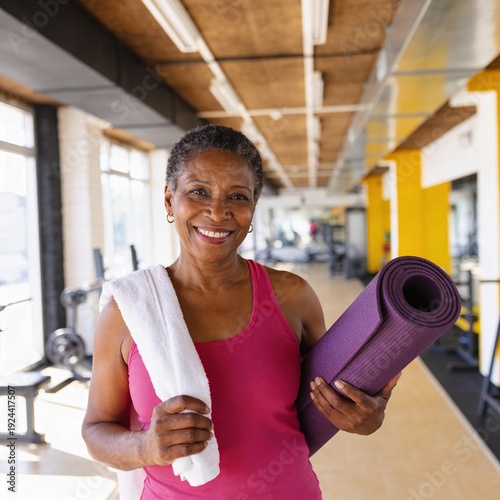 Smiling Senior Black Woman Holding Yoga Mat in Gym Active Healthy Lifestyle and Wellness
