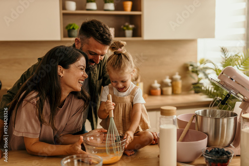 Фотография Family cooking together in modern kitchen laughing
