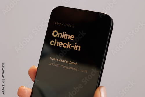 Close-up of a person using a smartphone for online flight check-in to Zurich, highlighting the ease and efficiency of modern digital travel preparation.