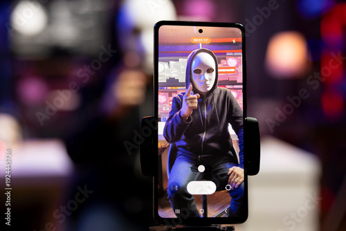 Photography Close up of smartphone used by hacker hidden in neon apartment to film video ultimatum to foreign governments