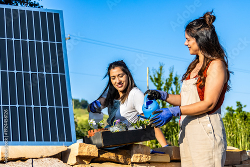 Women planting flowers near solar panel for sustainable ecology and renewable energy