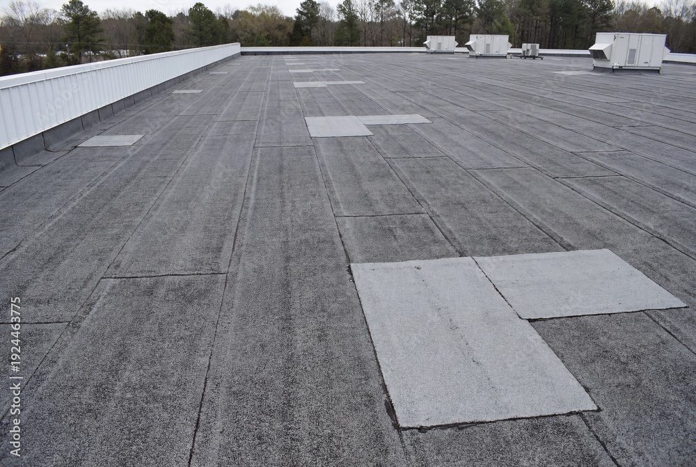 Fototapeta premium Flat commercial roof with modified bitumen surface and patches