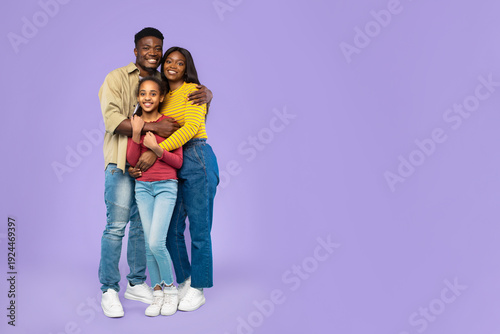 Φωτογραφία A father, mother, and daughter pose closely, smiling while embracing each other