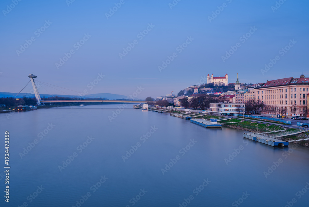 Naklejka premium Bratislava Castle and UFO Bridge Over Danube River at Dawn