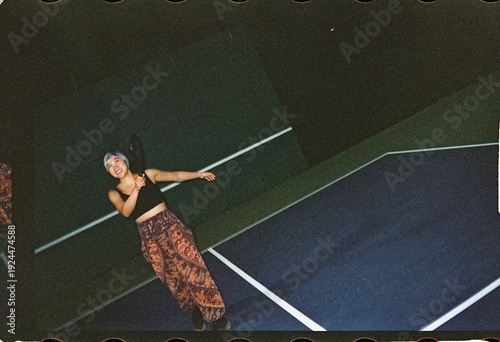Woman playing pickle ball at night 
