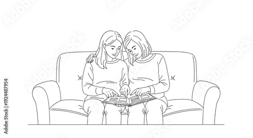 Two women sitting on a couch looking at a photo album together