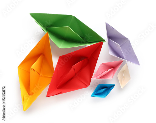 Colorful paper boats on whi...