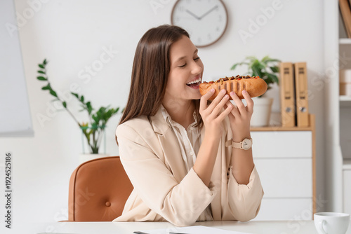 Young businesswoman eating ...