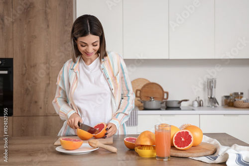 Young woman cutting grapefr...