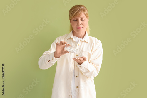 Mature woman taking vitamin...