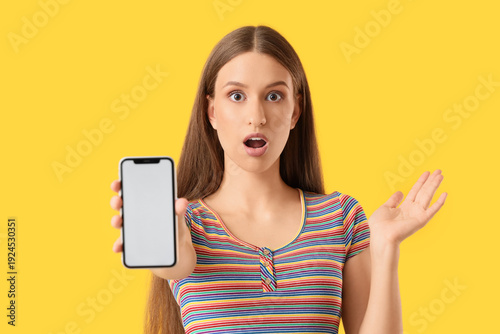 Surprised young woman showi...