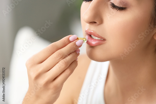 Young woman taking vitamin ...