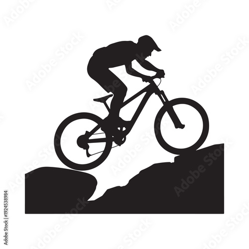 Silhouette of a mountain biker riding uphill on a rocky terrain