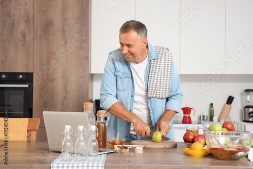Mature man with laptop cutt...