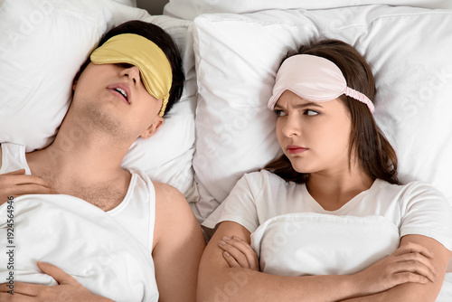 Young annoyed woman lying i...