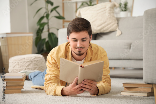 Young man reading book on c...