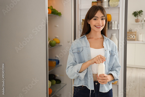 Young woman opening bottle ...