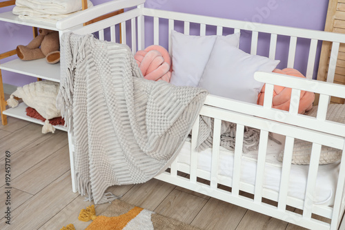 Crib with cozy blanket and ...