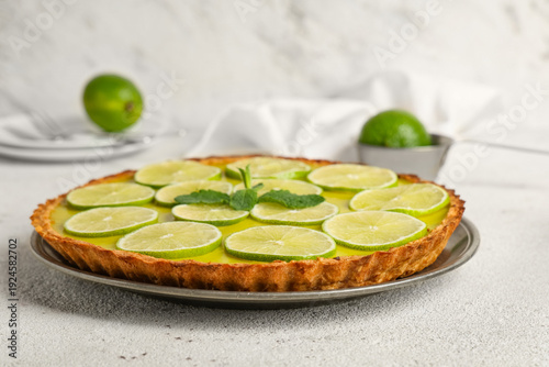 Plate of tasty lime tart with mint on white background © Pixel-Shot