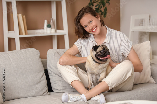 Young woman with cute pug d...