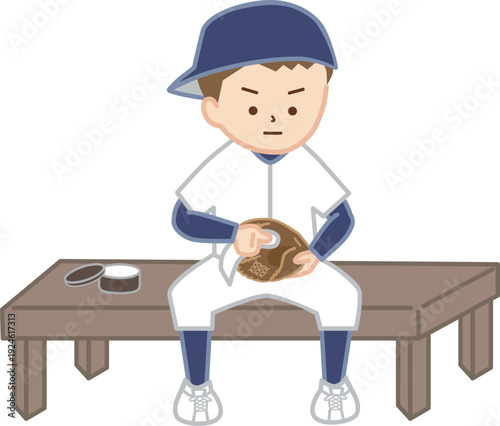 帽子を後ろに向きにかぶり、野球のグローブのお手入れをする男の子