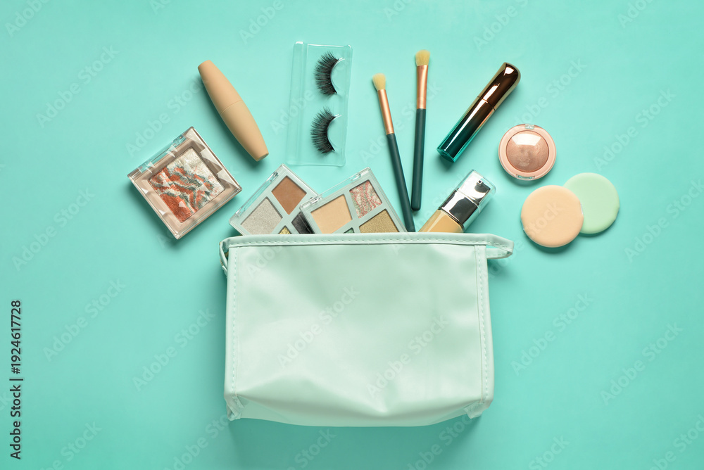 Naklejka premium Stylish cosmetic bag with makeup products on turquoise background