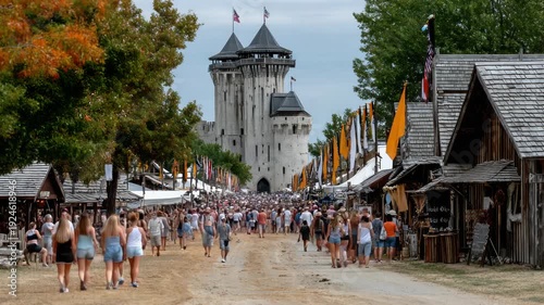Wallpaper Mural Large crowd walks down a dirt road toward a castle at a festival with shops on both sides Torontodigital.ca
