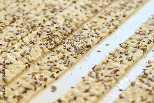 Εκτύπωση καμβά Cracker dough ribbons on conveyor belt showcasing strips with sesame seeds and s