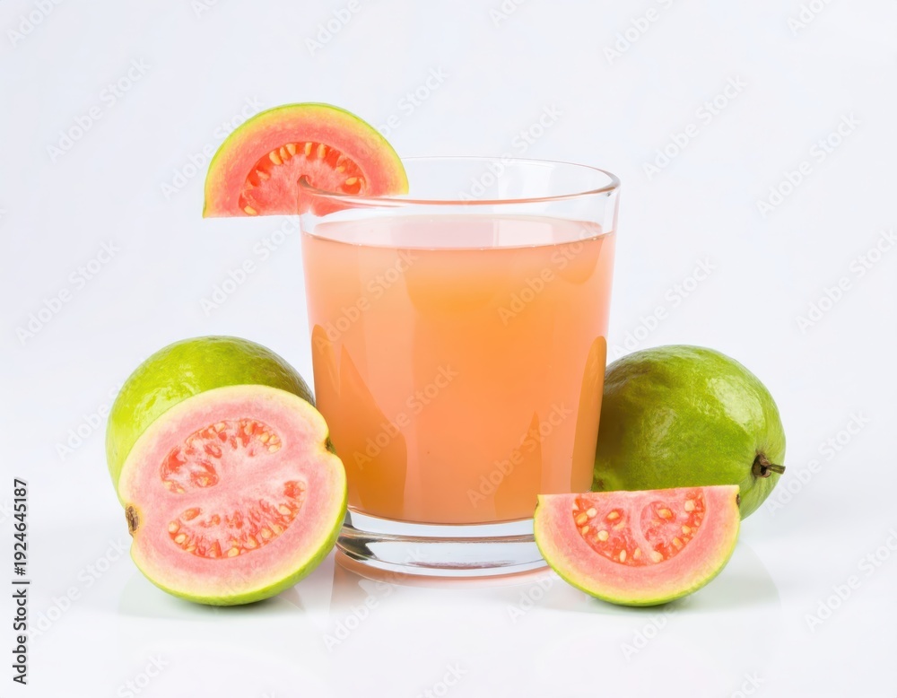 Fototapeta premium Glass of fresh pink guava juice with whole and sliced guavas on white background