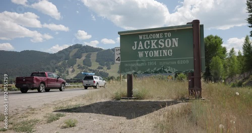 Welcome to Jackson Wyoming Sign with Passing Traffic in Summer