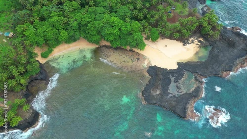 Viewed from above, the beautiful piscina beach and its transparent sea, surrounded by palm trees at south of São Tomé,Africa
