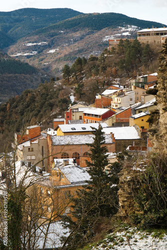 Typical mountain village with the roofs of the houses covered in snow.