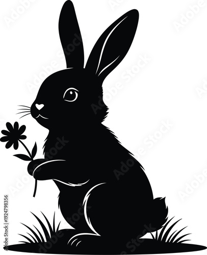 A charming black silhouette illustration of a cute rabbit sitting on grass and delicately holding a small flower with its paws, perfect for spring designs.