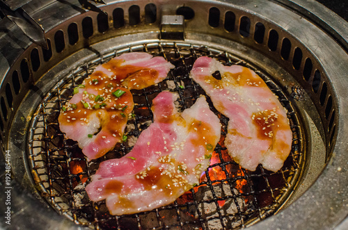 Korean BBQ Pork Slices Grilling on Charcoal Stove