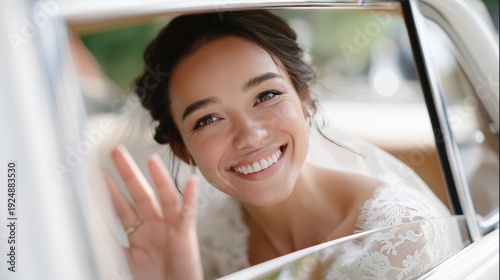 Beautiful happy bride waving hand from a vintage wedding car.