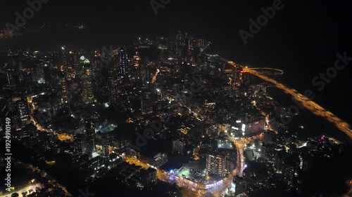 Night view of the Mumbai Coastal Road in Maharashtra, India, famously known as the 'City of Dreams.' The scene captures a multileveled interchange roadway. A complex road network and urban design.