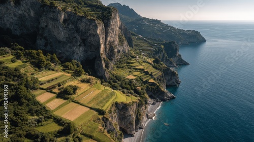 Coastal Harmony: An aerial view showcases the serene meeting of dramatic cliffs, terraced farmland, and the endless sea, a symphony of nature's artistry and human endeavor.