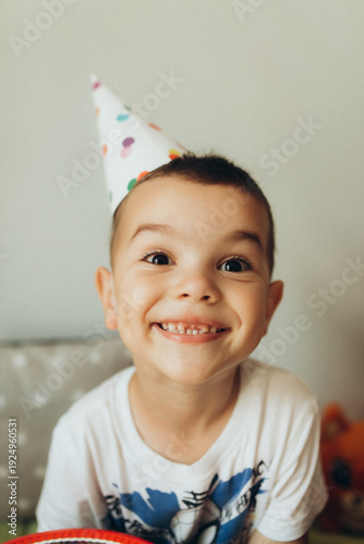Fotografie Happy young boy wearing colorful party hat and smiling