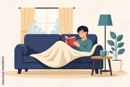 Young man relaxing at home on sofa, reading book, enjoying leisure and comfort