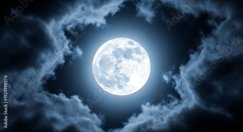 Bright full moon shining through dark clouds in the night sky.