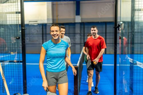 Εκτύπωση καμβά Young woman smiling entering padel court with friends