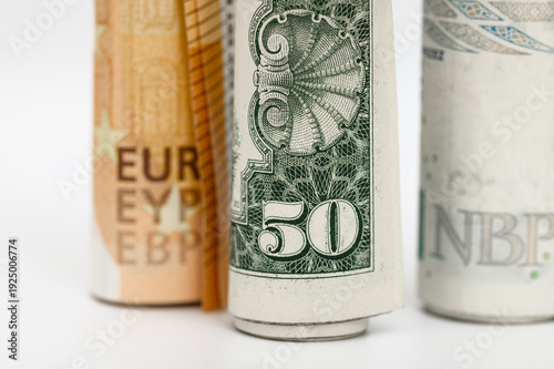 Tableau sur toile Close-up of three different physical paper money rolled up into rolls, currency