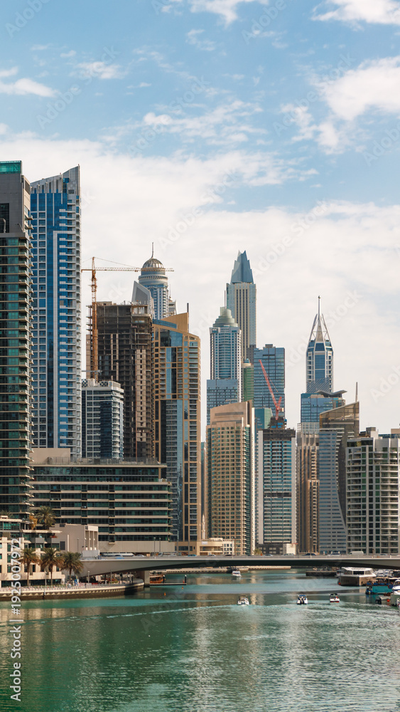 Obraz premium Skyline view of Dubai with modern buildings and a river on a clear day