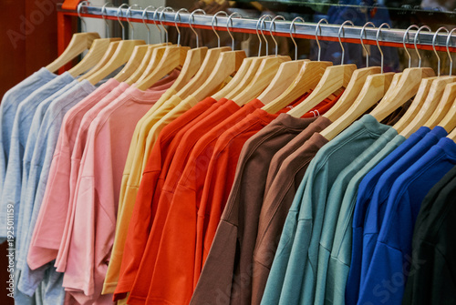 Colorful T-Shirts on Wooden Hangers in Clothing Store