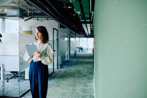 Fotografi Professional businesswoman using a digital tablet while moving through a sleek,