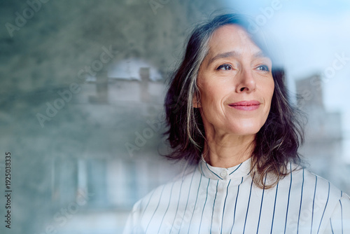 Photos Confident businesswoman smiling, looking away from camera, reflecting on plans,