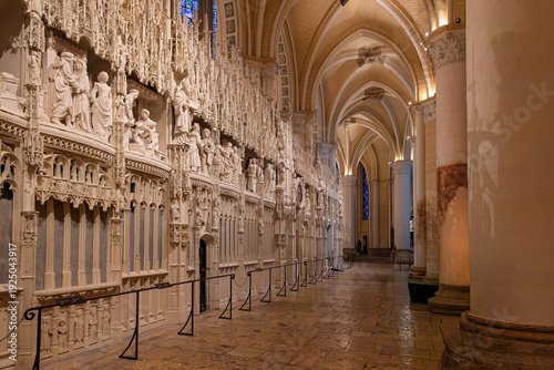 Sculpted choir screen and side aisle inside Chartres Cathedral, a UNESCO World Heritage Site in France, highlighting intricate Gothic stonework, arches and historic sacred interiors.